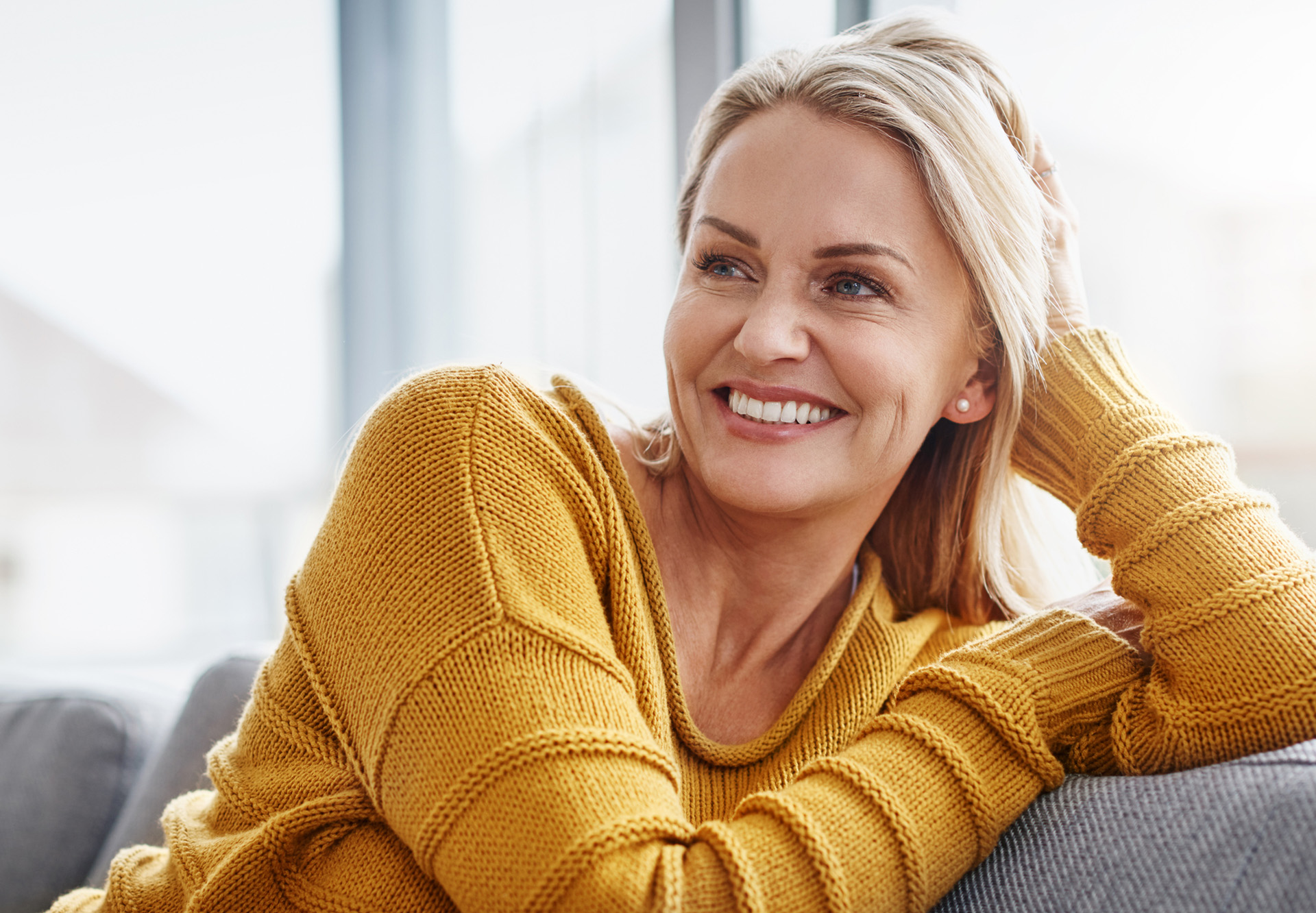 smiling in yellow knit sweater